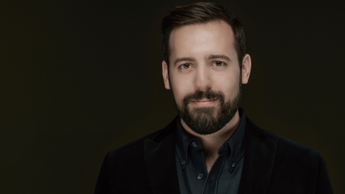 Headshot of Chase Hopkins, dark suit, dark background