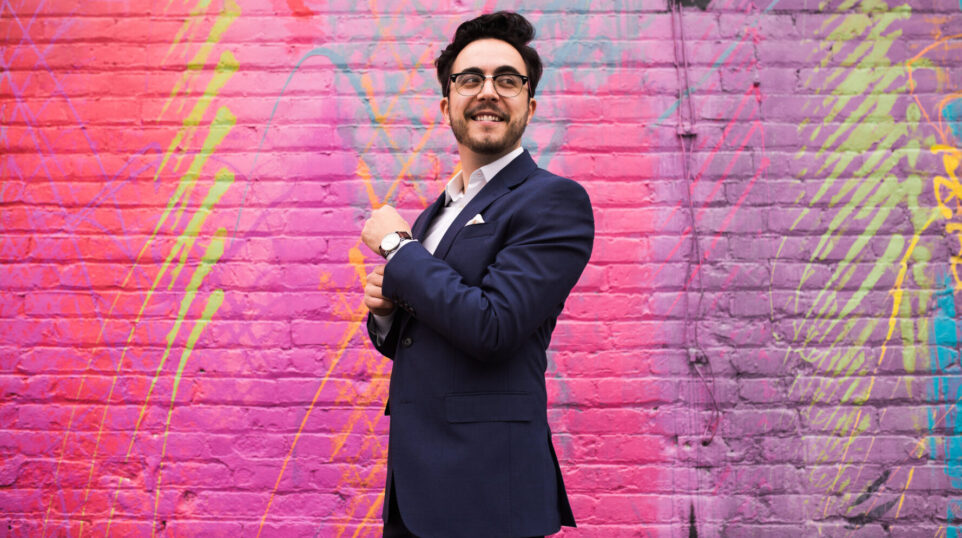 Julian Velasco in front of a bright, multicolored wall