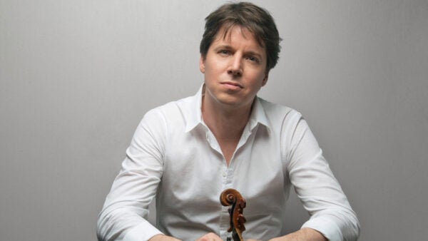 Man holding violin in front of white background