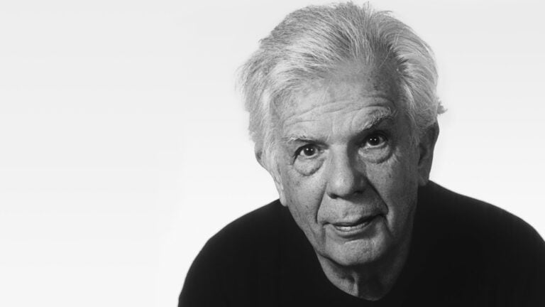 Headshot of conductor Christoph von Dohnányi, dressed in dark clothing, half smiling at camera