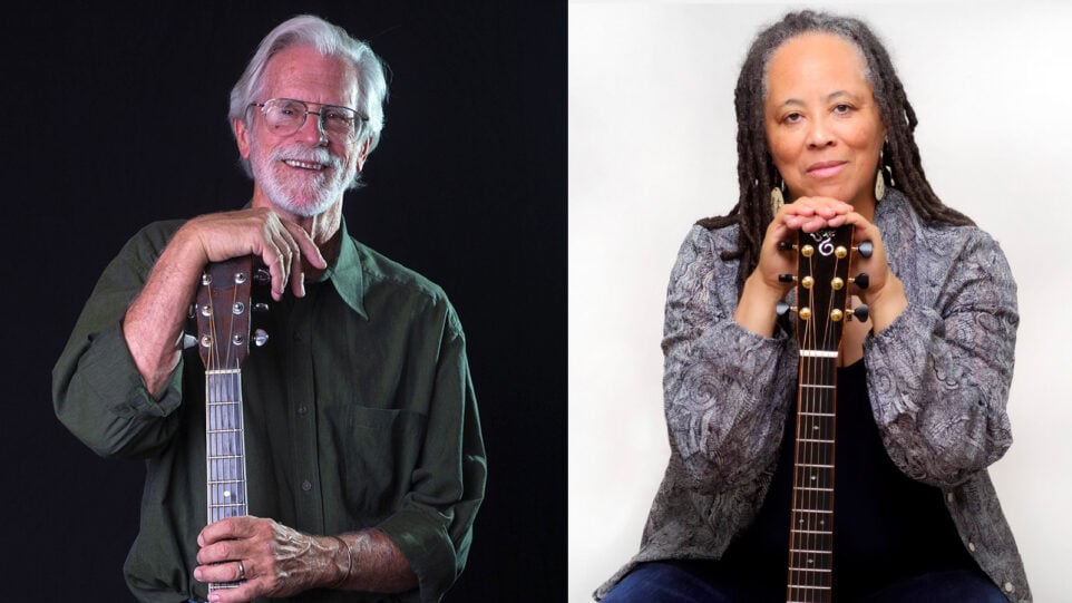 man stands with guitar and woman sits with guitar