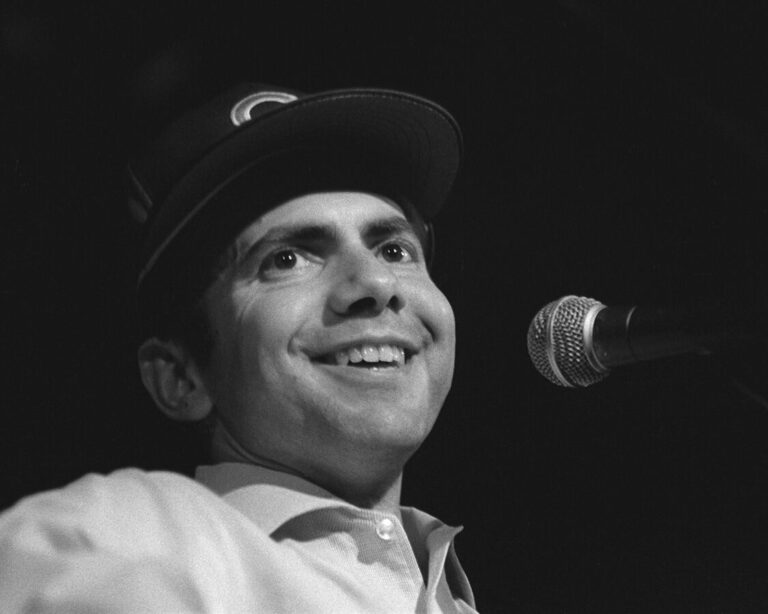 man in Cubs hat at microphone