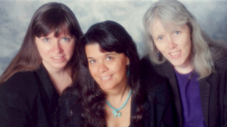 three woman look into camera