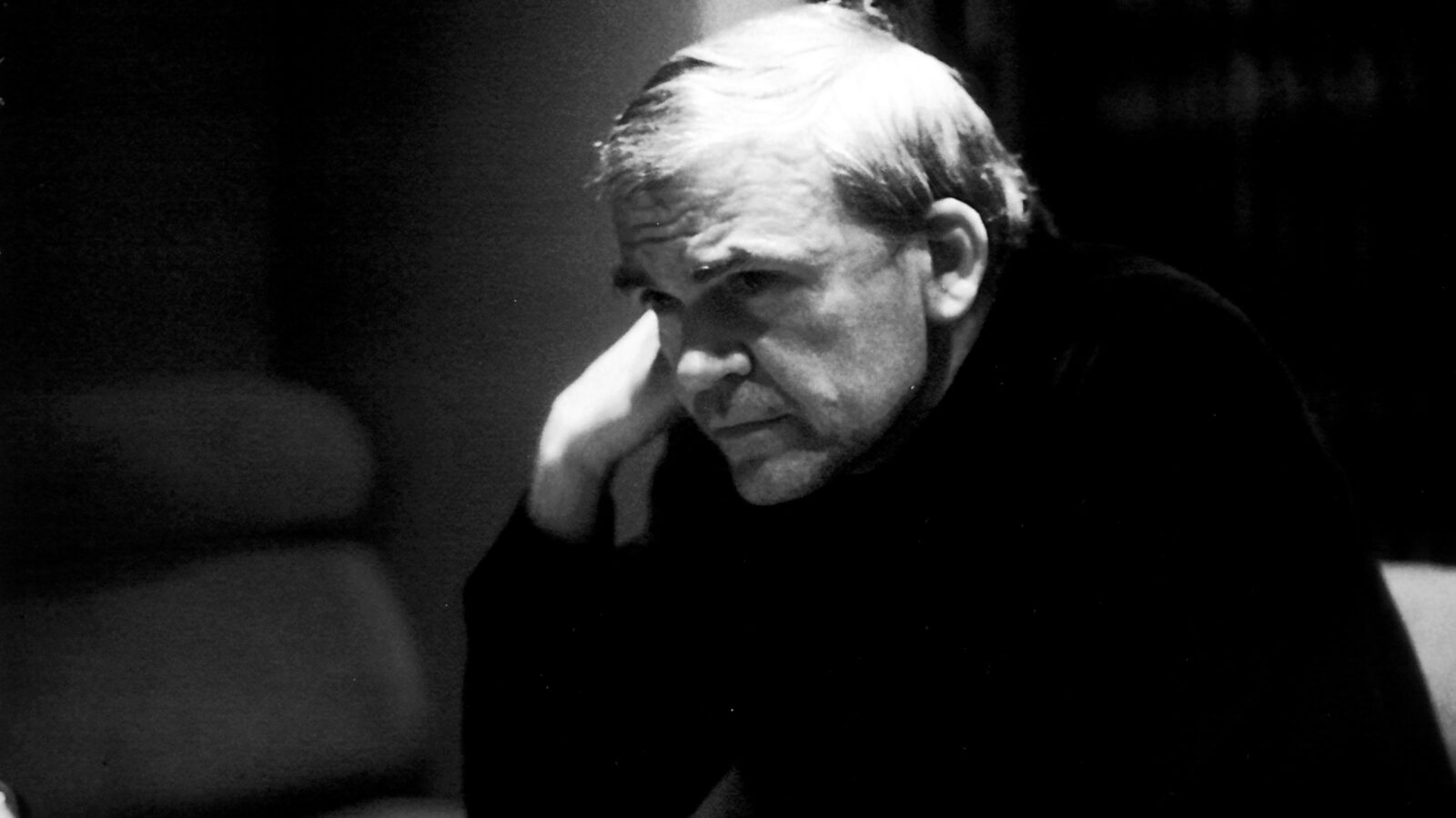 Black and white photo of Milan Kundera, seated and deep in thought