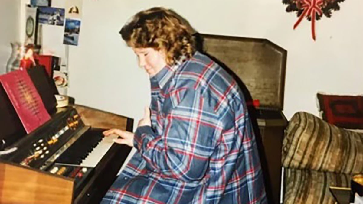 Patty Nystedt, wearing a plain shirt, plays a keyboard