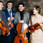 The members of Balourdet Quartet share a laugh holding their instruments