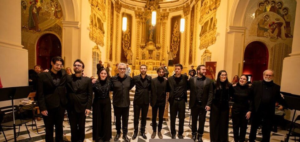 11 people dressed in concert black in a an ornate monastery