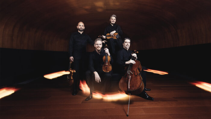 The Quartetto di Cremona poses in a dimly lit room with light streaks