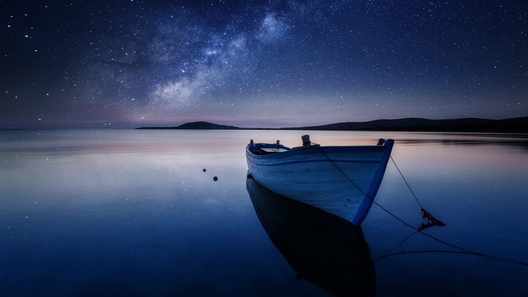 a rowboat tethered under an ethereal, dreamlike night sky reflected in perfectly still waters