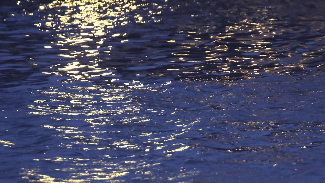 lights reflect on dark twilight waves