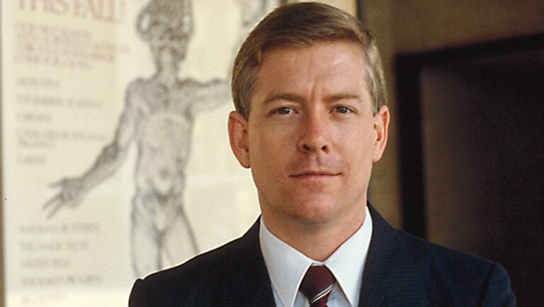 Christopher Keene poses with an opera billboard