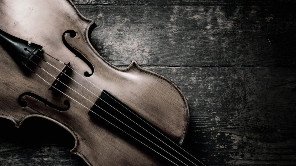 rustic faded violin on a worn wood table