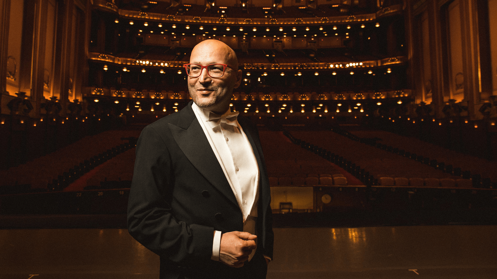 Photo of Enrique Mazzola on an empty stage at Lyric Opera.