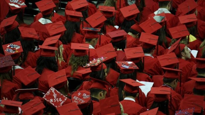 overhead view of a crowd of grads wearing red mortar boards.
