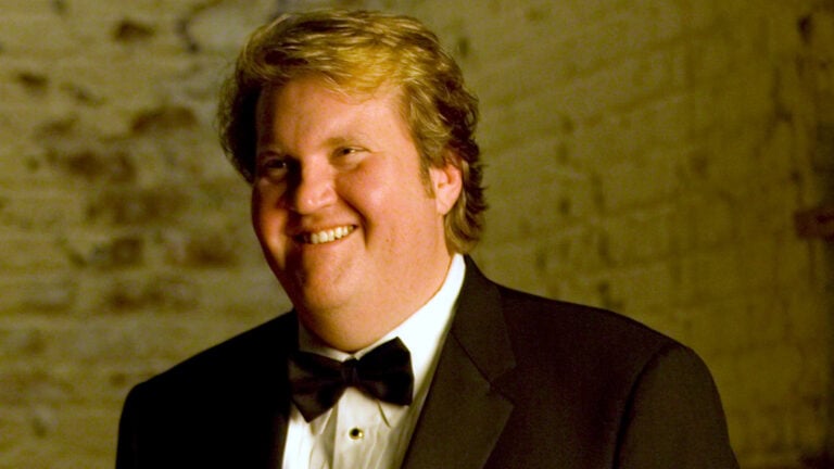Tenor Anthony Dean Griffey in a tux in front of a rustic brick wall