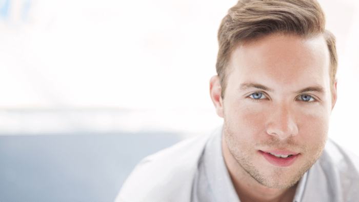 Portrait of Christopher Lowrey in a white shirt, brightly exposed with a light background.