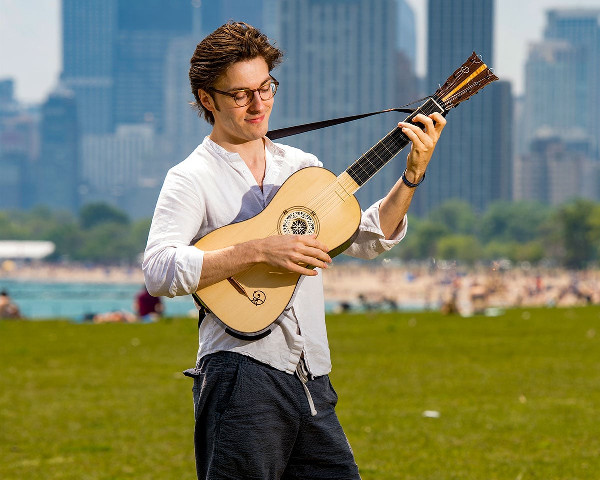 Instrumental performer in Chicago on sunny day with skyline in background