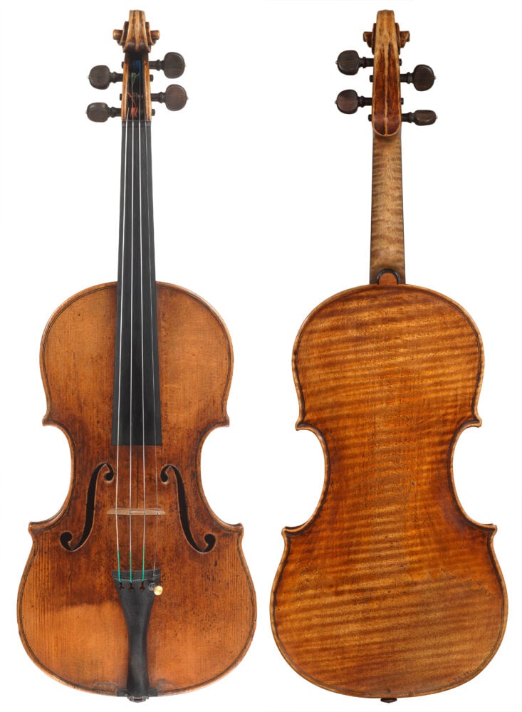 A photo of an old Guarnari violin from 1742. It is a light brown in color with an orange tinge, and a dark splat on the center, towards the left F hole in the front. The back of the violin has a diagonal tiger pattern lines going across the instrument. 