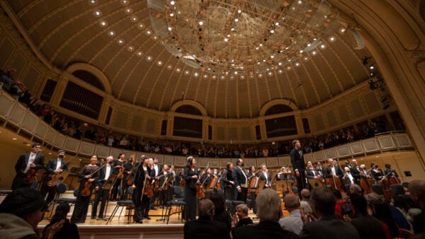 Conductor and orchestra musicians receive the applause of the audience at Chicago's Symphony Center