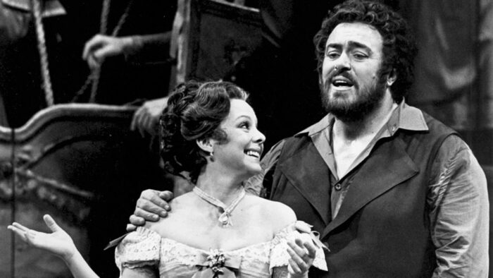 Judith Blegen and Luciano Pavarotti perform together in costume and onstage in a black and white photo from 'L'Elisir d'Amore'