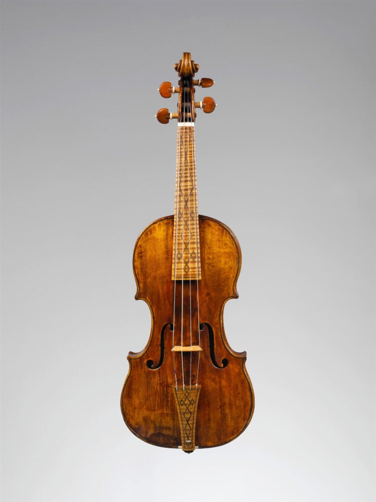 image of the front of a violin with interesting ornament pattern on frets and tailpiece