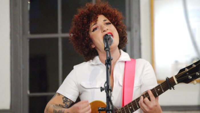 woman plays guitar and sings