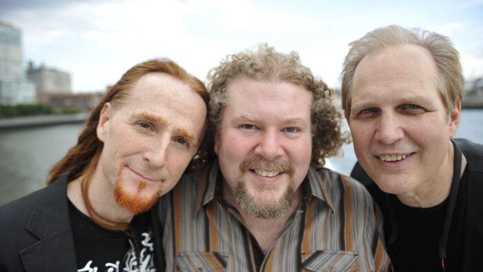 three men look into camera