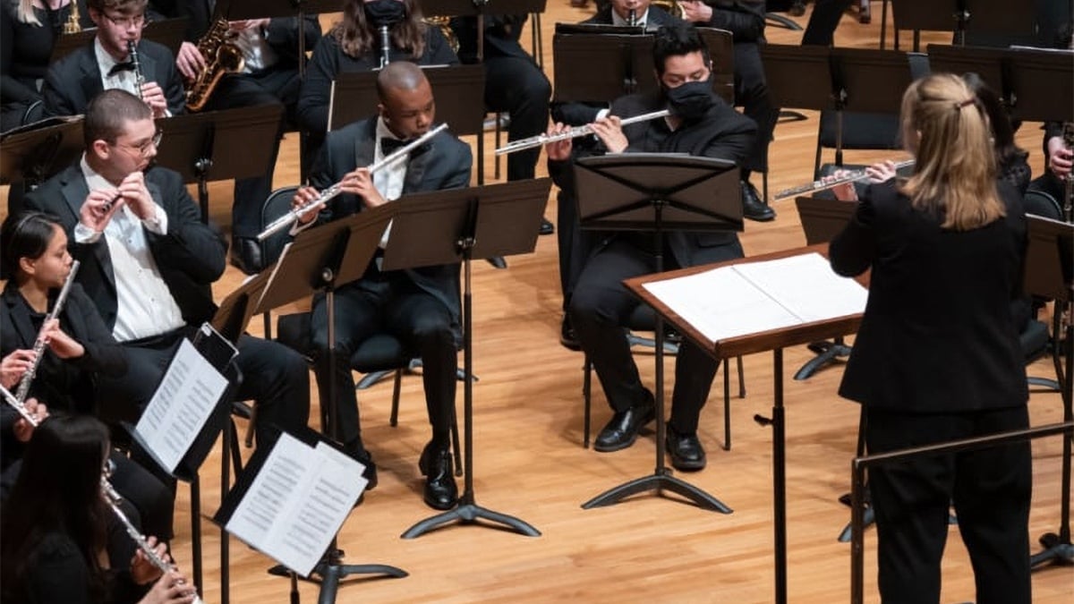 The DePaul University Wind Symphony performing on stage with conductor Erica Neidlinger