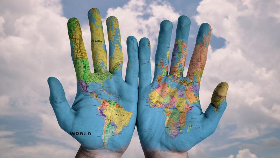 world map painted on the palms of two hands