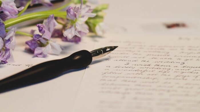 fading flowers, a fountain pen and paper with handwriting