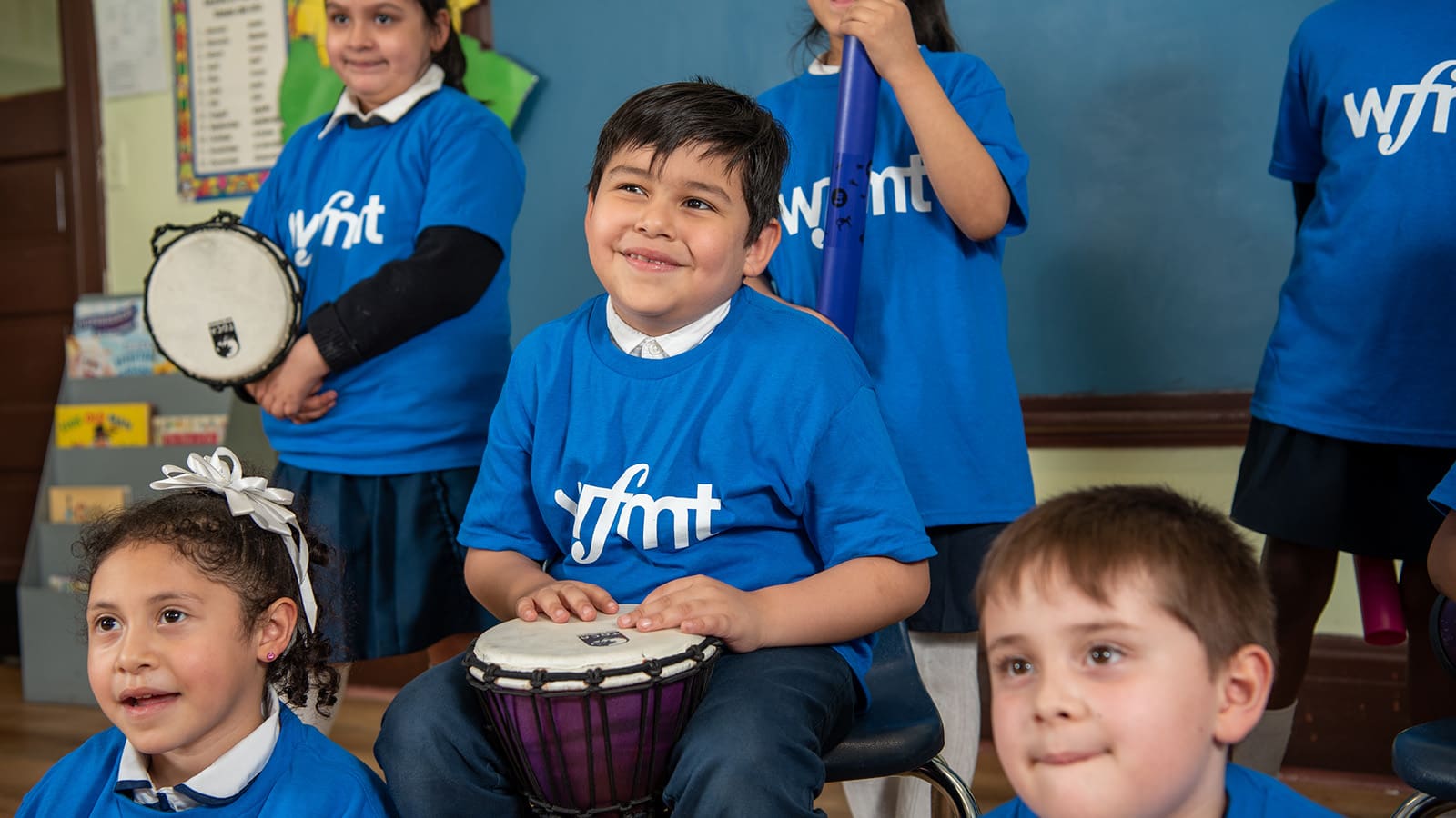 School students playing djembe drums