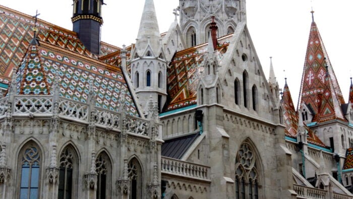 a castle church with Gothic architecture added to the original Romanesque building with a roof of tiles of different shapes and colors