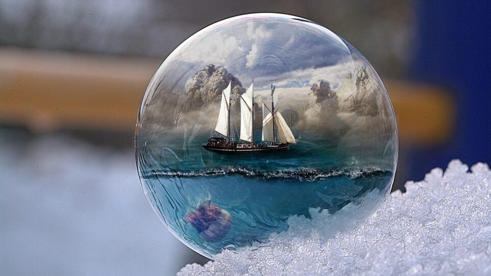 a sailing ship reflected in a glass bubble on a pile of snow