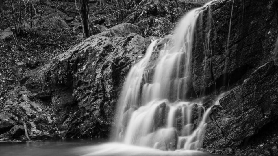 A Small river creating a waterfall falling through different rock s