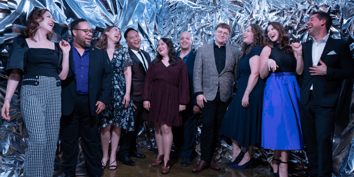 Members of Chicago a cappella posing in front of a silver background