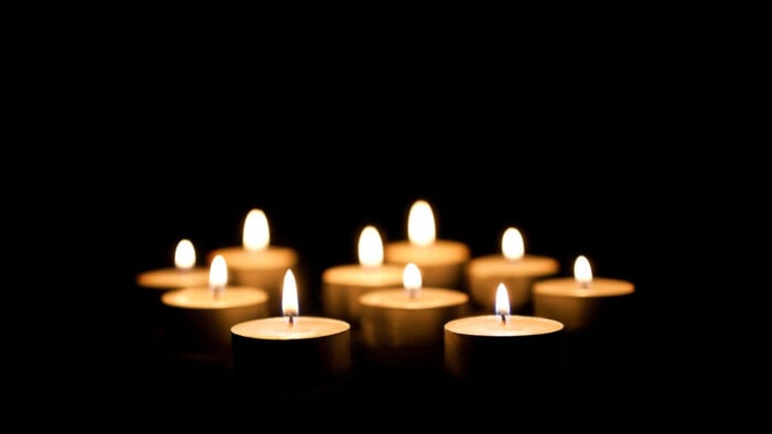 votive candles lit against a black background