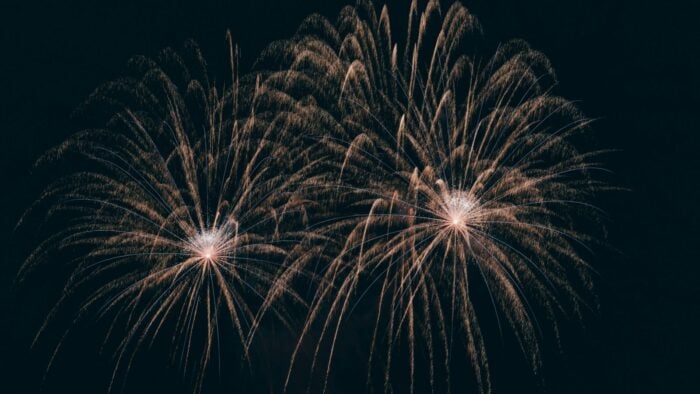 Golden fireworks exploding in a dark sky.