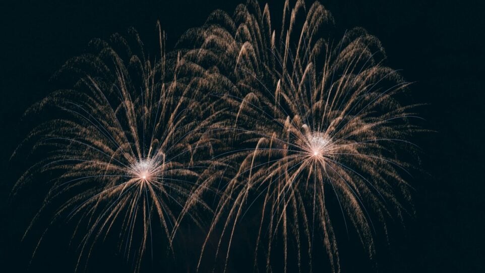 Golden fireworks exploding in a dark sky.