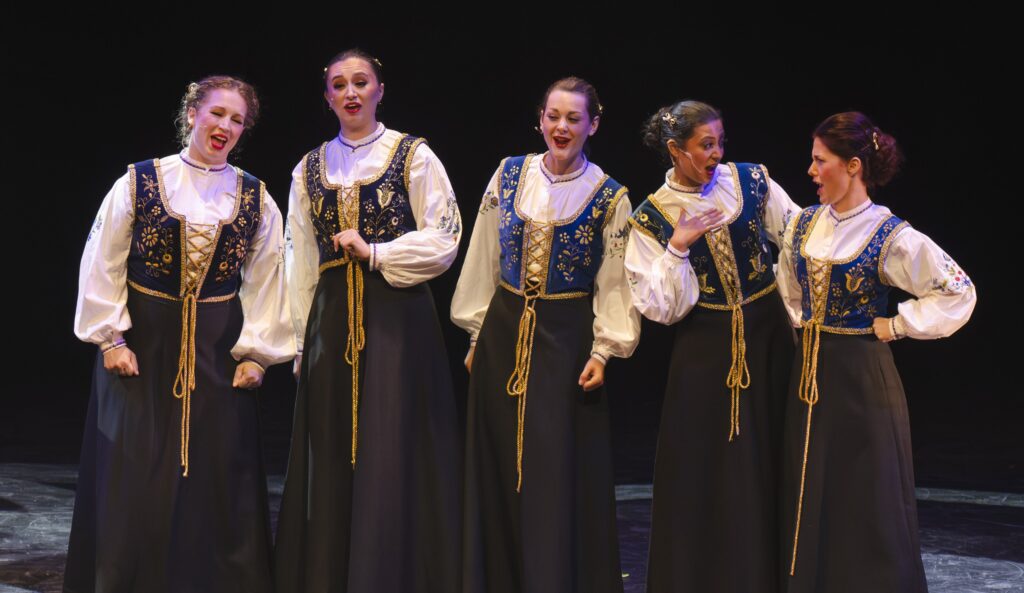 Members of the Lira Ensemble performing on stage in costume