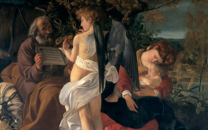 A bearded and grey-haired man sits on a large parcel, holding a book of music. In front of him is an angel playing the violin. A woman sits beside him, cradling in her arms an infant.