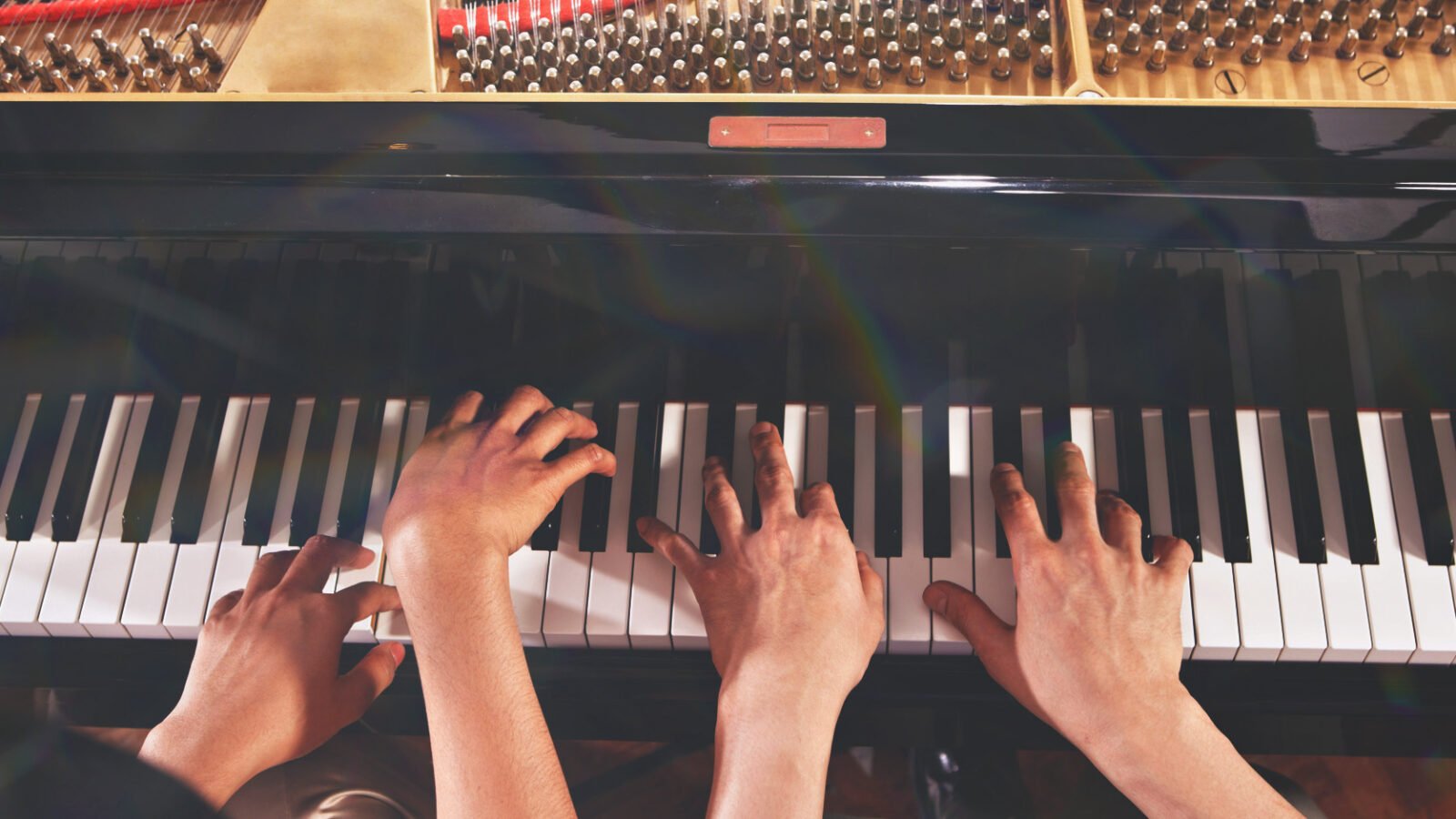 Overhead shot of two pianists playing piano four hands