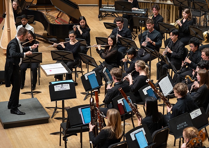Members of the Northwestern University Symphonic Wind Ensemble performing on stage