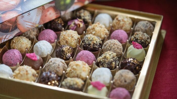 an opened box of multi-colored chocolates