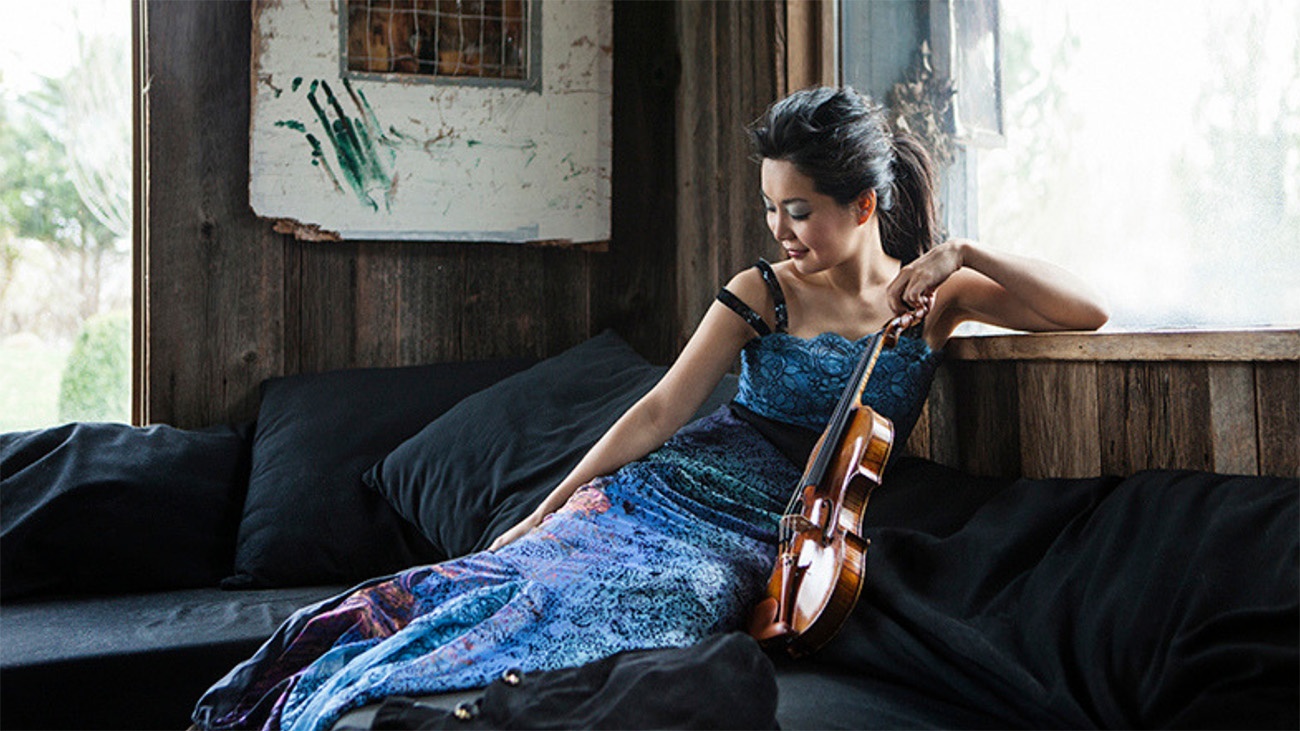 Violinist Susanne Hou poses with her instrument wearing a blue dress