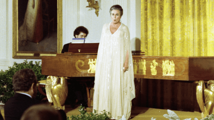 Soprano Phyllis Curtin Performing in a flowing ecru gown performing at a piano in the East Room of the White House, unnamed pianist at her right.