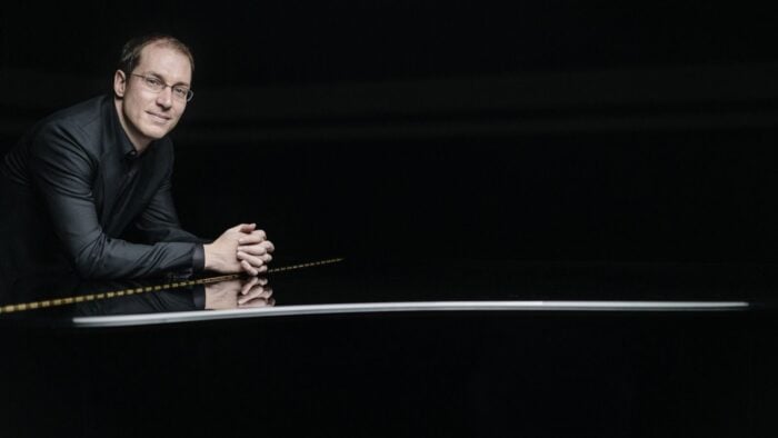 Man leans against piano