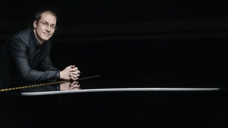 Man leans against piano