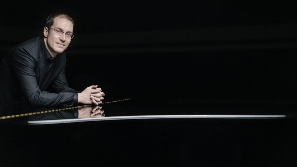 Man leans against piano