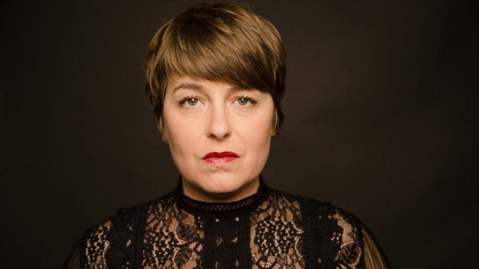 Serious woman in front of dark background