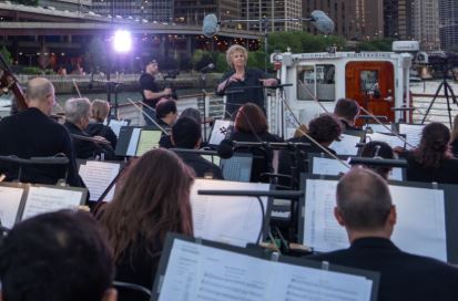 Jane Glover conducts members of Music of the Baroque on a boat on the Chicago River